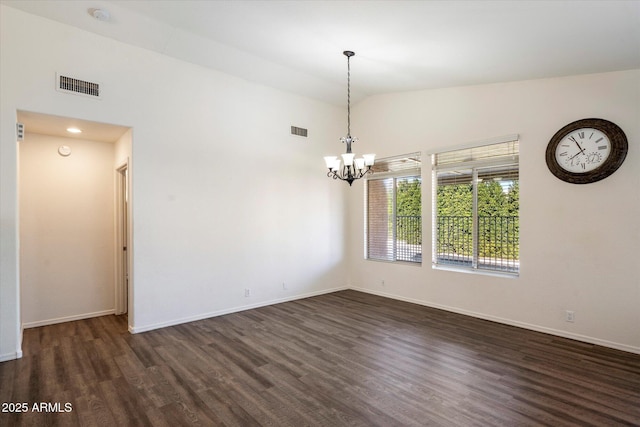 empty room featuring vaulted ceiling, dark wood-type flooring, and a chandelier