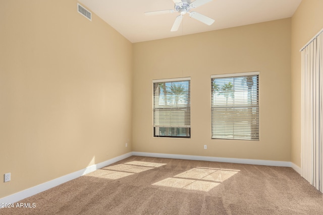 carpeted spare room with ceiling fan