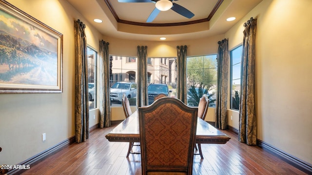 dining room with hardwood / wood-style flooring, ceiling fan, a raised ceiling, and crown molding