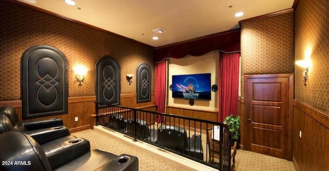 cinema room featuring carpet, wood walls, and crown molding