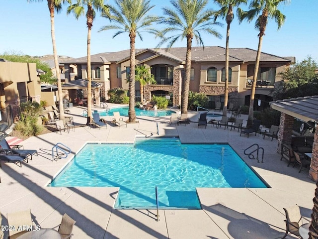 view of swimming pool featuring exterior fireplace and a patio