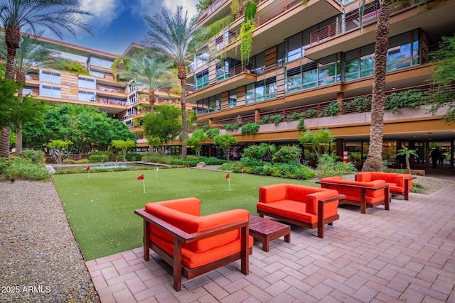 view of home's community with a putting area, an outdoor hangout area, and a patio area