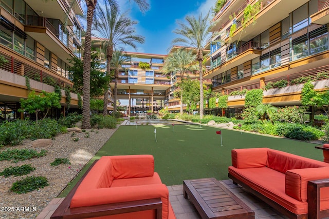 view of property's community with an area to practice putting and an outdoor hangout area