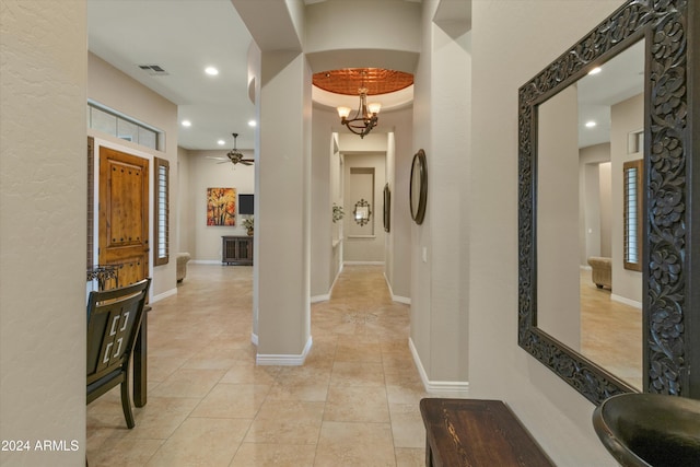 hallway with a notable chandelier, light tile patterned floors, and sink