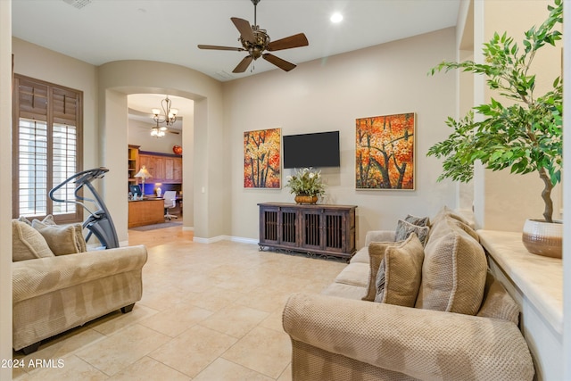 living room featuring light tile patterned flooring and ceiling fan with notable chandelier