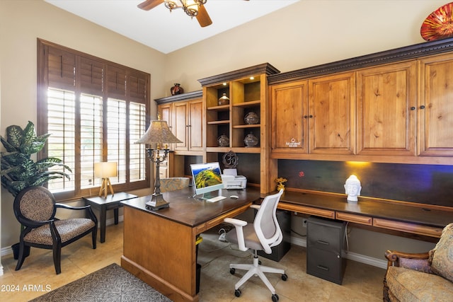 office featuring ceiling fan, light tile patterned flooring, and built in desk