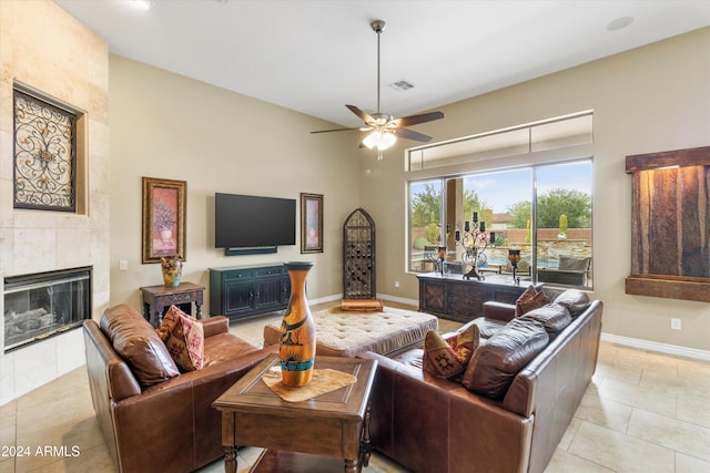 living room with a fireplace, light tile patterned floors, and ceiling fan