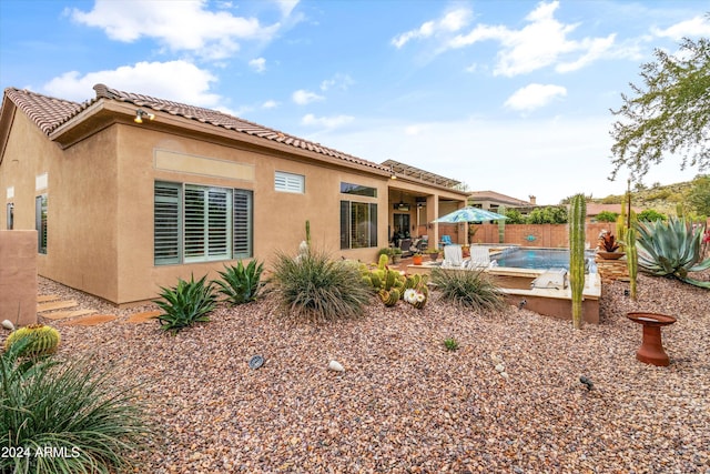 back of property featuring a patio area and a fenced in pool