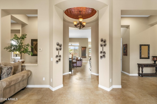 foyer featuring a notable chandelier and a tray ceiling