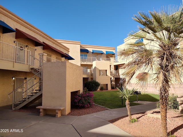 view of home's community featuring stairs and a yard