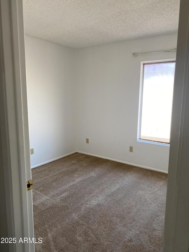 carpeted spare room featuring a textured ceiling