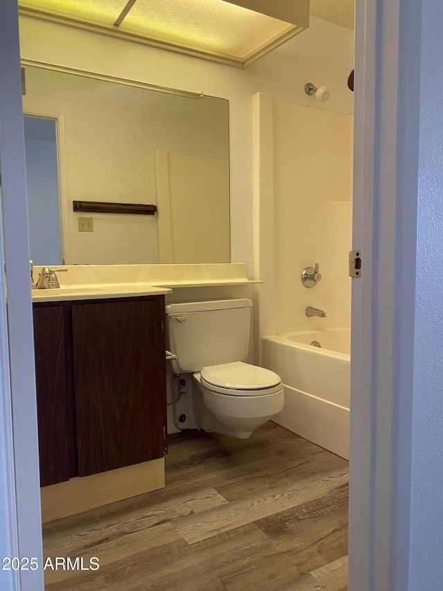 full bathroom featuring vanity, hardwood / wood-style floors, shower / bathtub combination, and toilet