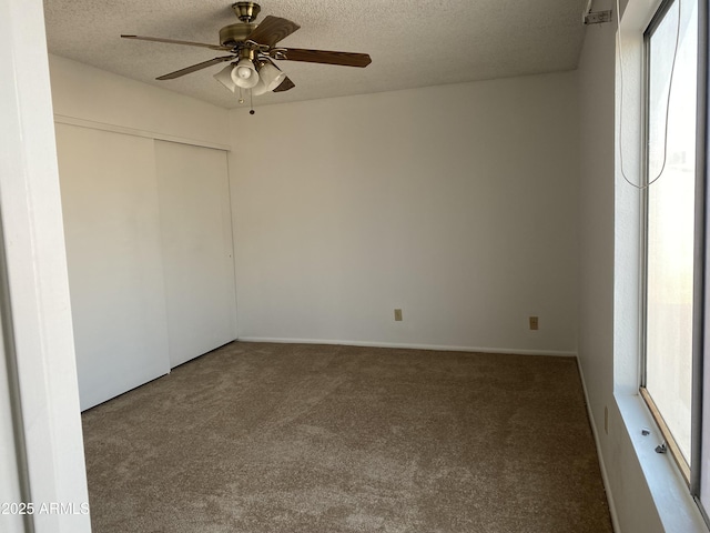 spare room with ceiling fan, carpet, and a textured ceiling