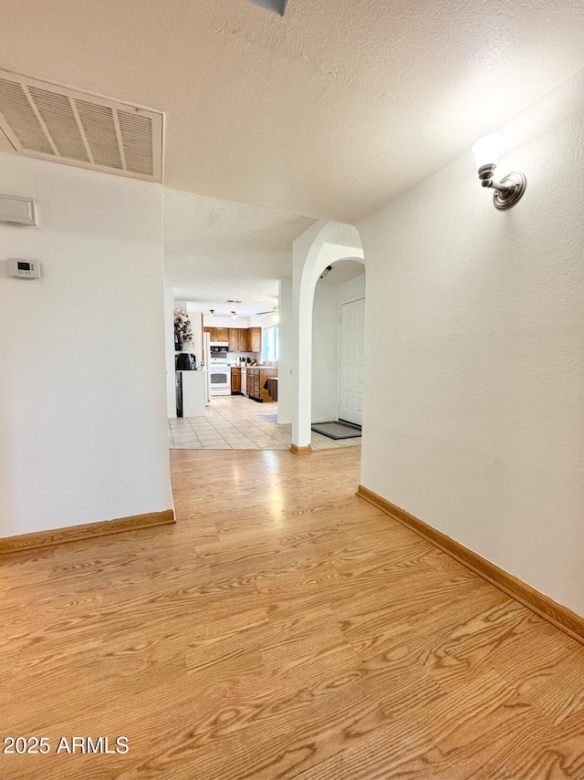 corridor featuring light hardwood / wood-style flooring and a textured ceiling