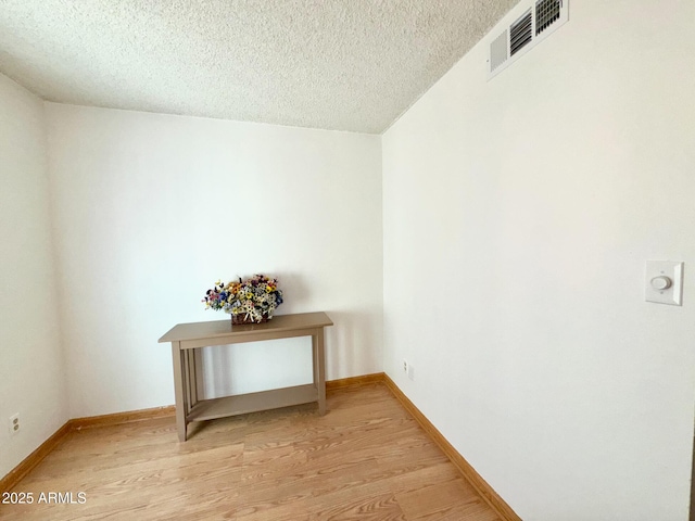 interior space featuring a textured ceiling and light wood-type flooring