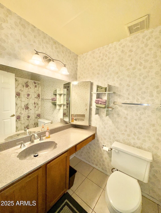 bathroom with tile patterned flooring, vanity, and toilet