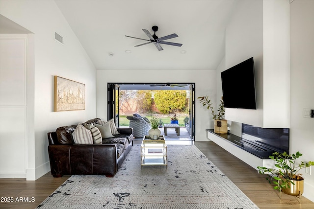 living room featuring high vaulted ceiling, ceiling fan, visible vents, and wood finished floors