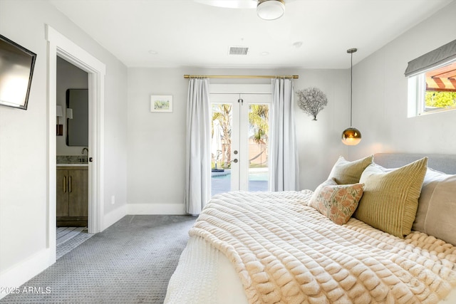 carpeted bedroom featuring access to exterior, french doors, visible vents, ensuite bath, and baseboards