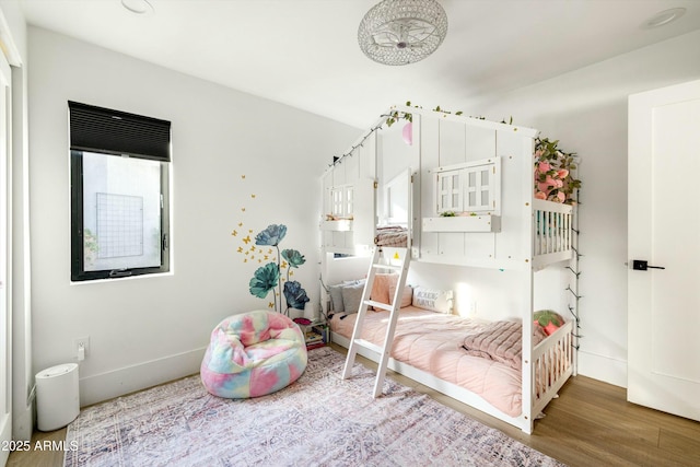 bedroom with baseboards and wood finished floors