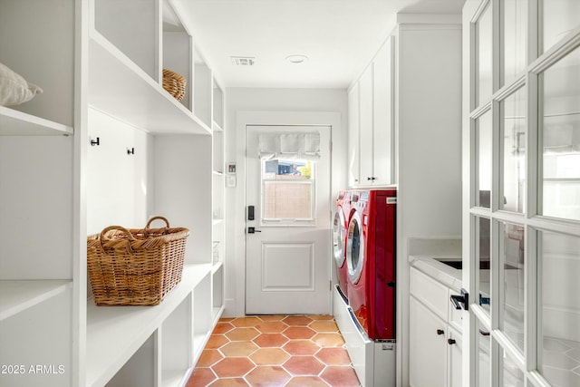 laundry room featuring cabinet space, washer and clothes dryer, and light tile patterned flooring