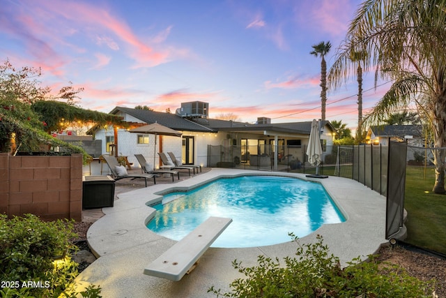 view of pool with a fenced in pool, central air condition unit, a patio area, a fenced backyard, and a diving board