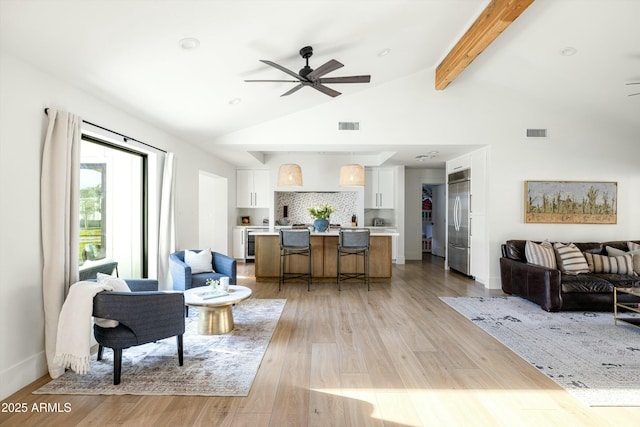 living area with light wood-style floors, beam ceiling, visible vents, and a ceiling fan