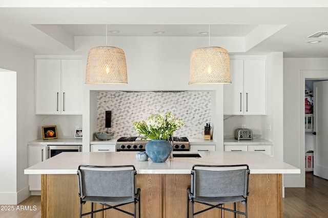 kitchen with light wood-type flooring, a breakfast bar, and light countertops