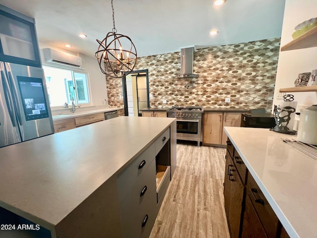 kitchen with light hardwood / wood-style flooring, an AC wall unit, stainless steel appliances, decorative backsplash, and wall chimney range hood