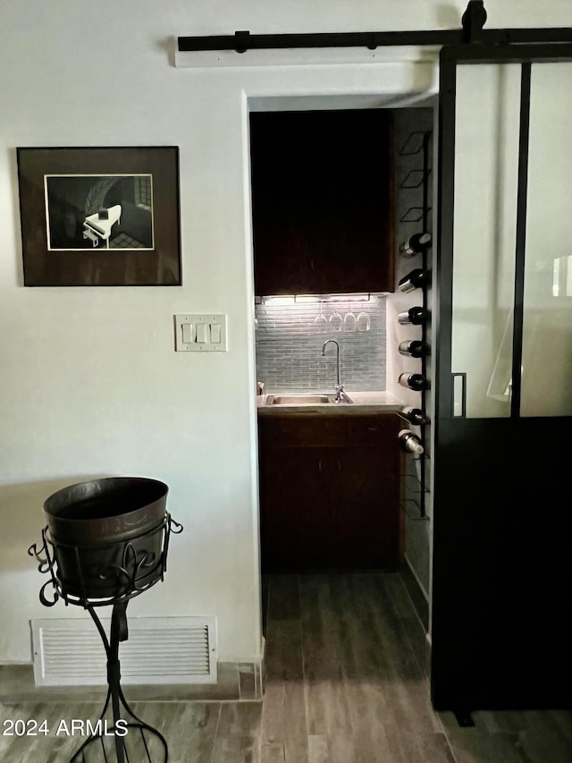 interior space featuring sink, decorative backsplash, and wood-type flooring