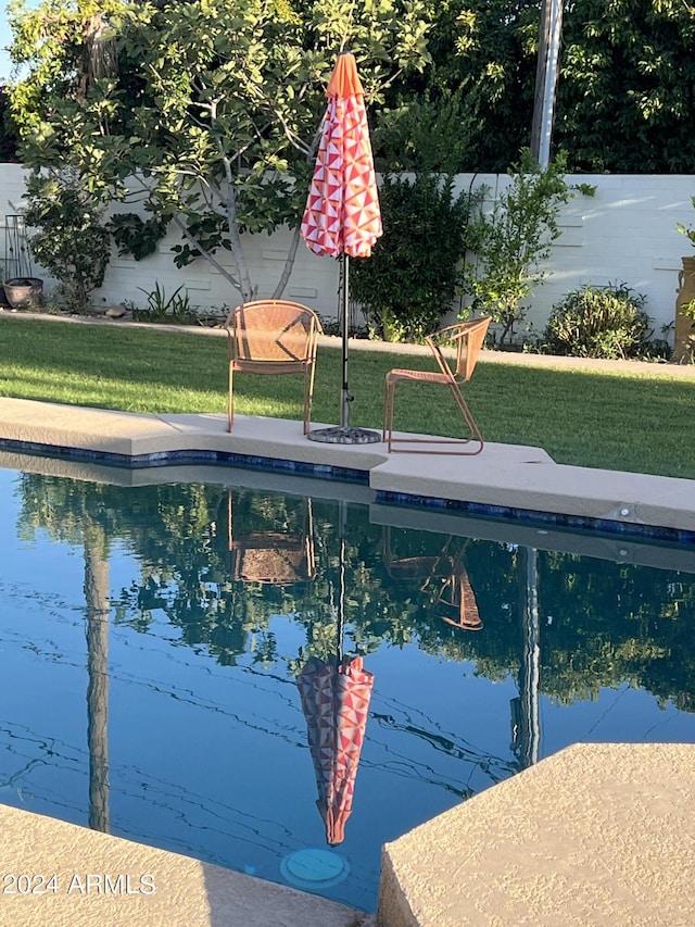 view of swimming pool with a yard