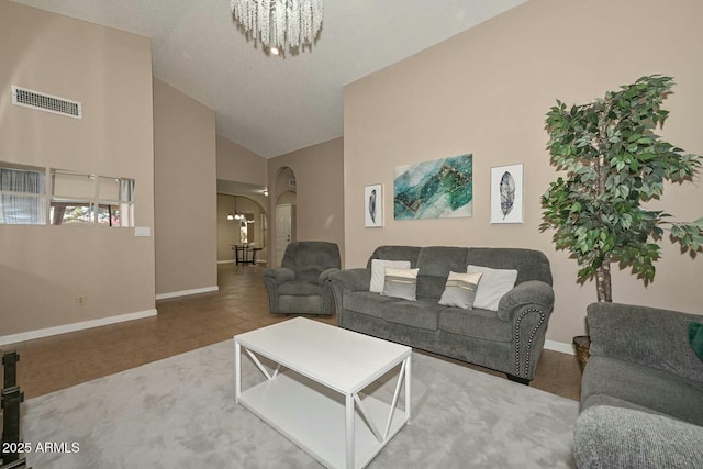 living room featuring a chandelier and high vaulted ceiling