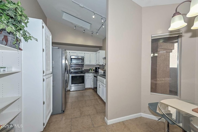 kitchen with decorative light fixtures, white cabinetry, vaulted ceiling, and appliances with stainless steel finishes