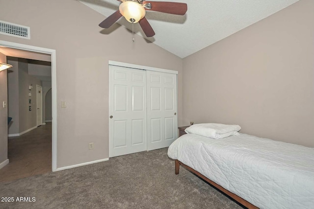 carpeted bedroom with a closet, vaulted ceiling, and ceiling fan