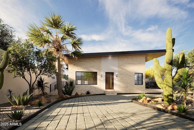 view of front facade with a patio area and fence