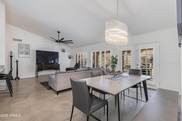 dining room featuring concrete flooring, lofted ceiling, visible vents, and ceiling fan with notable chandelier