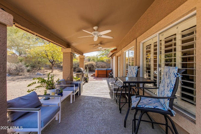 view of patio / terrace with a fenced backyard, ceiling fan, and a hot tub