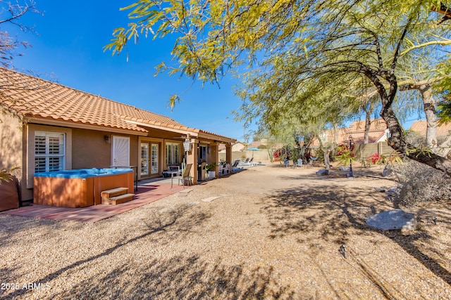 view of yard featuring french doors, a patio area, fence, and a hot tub