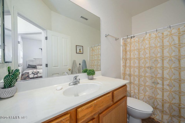 ensuite bathroom with toilet, vanity, visible vents, and connected bathroom