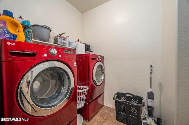 clothes washing area featuring laundry area, tile patterned flooring, and washer and dryer