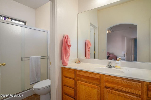 bathroom featuring toilet, vanity, a shower stall, and ensuite bathroom