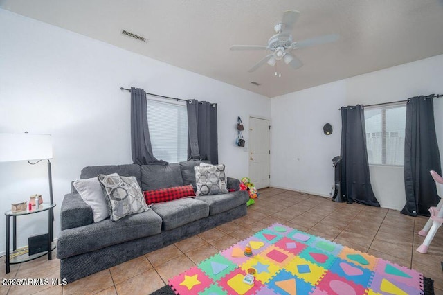 tiled living room with visible vents and ceiling fan
