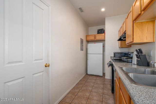 kitchen featuring under cabinet range hood, a sink, visible vents, black electric range, and freestanding refrigerator