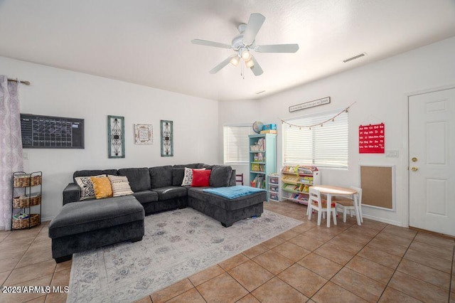living area featuring light tile patterned flooring, visible vents, and a ceiling fan