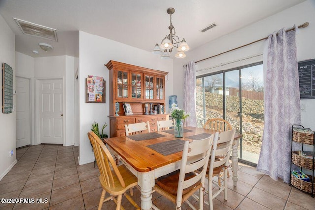 dining space featuring light tile patterned flooring, visible vents, and an inviting chandelier