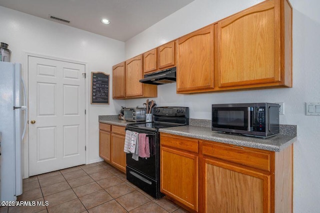 kitchen featuring visible vents, freestanding refrigerator, tile patterned flooring, under cabinet range hood, and black range with electric cooktop