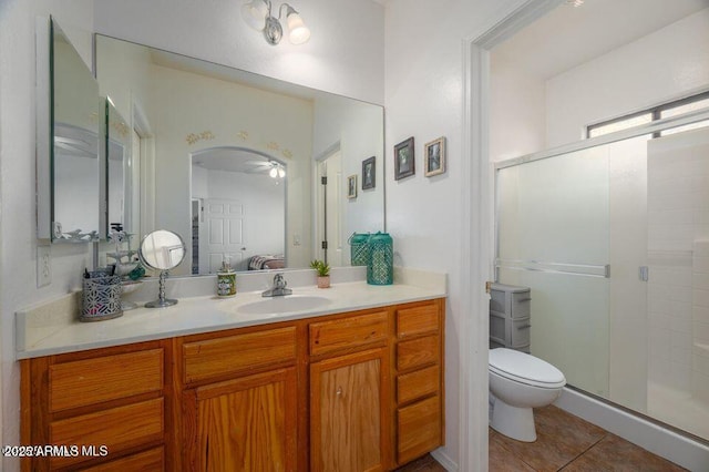 full bath with a stall shower, tile patterned flooring, vanity, and toilet
