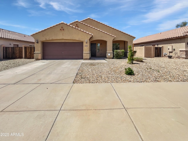 8616 S 57th Dr, Laveen, AZ 85339 - mediterranean / spanish house featuring a tiled roof, an attached garage, fence, stucco siding, and driveway
