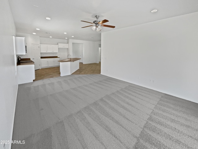 8616 S 57th Dr, Laveen, AZ 85339 - unfurnished living room with a sink, a ceiling fan, light colored carpet, and recessed lighting