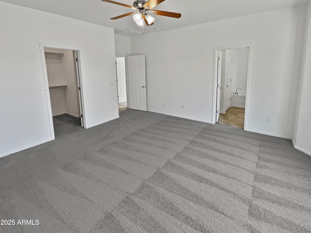 8616 S 57th Dr, Laveen, AZ 85339 - unfurnished bedroom with carpet flooring, a spacious closet, a ceiling fan, and connected bathroom