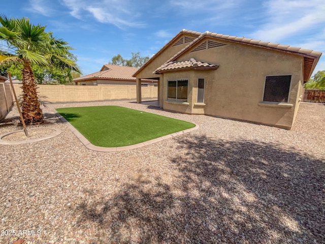 8616 S 57th Dr, Laveen, AZ 85339 - back of property with a tiled roof, a patio area, a lawn, a fenced backyard, and stucco siding